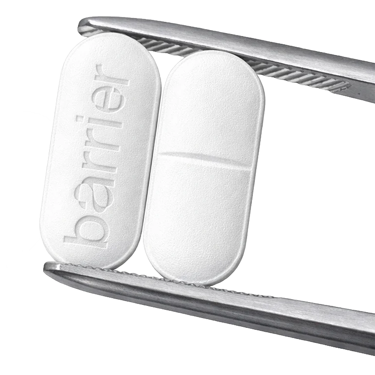 Two white Barrier tablets held in silver tweezers
